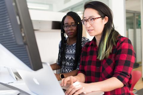 Two people sat at a computer.